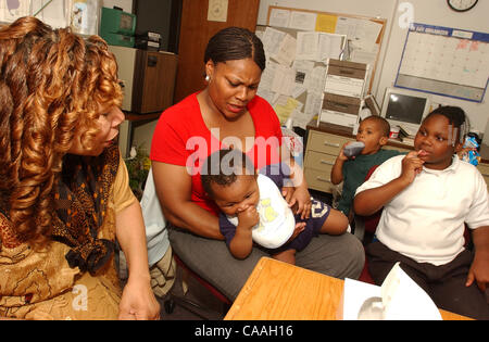 Jun 05, 2003 - Cincinnati, Ohio, USA - PATRICIA LOVEJOY (L) directeur de la foi de l'église de Morningstar basée programme de soutien pour les personnes en difficulté un parle avec 'client' TRACEY capable, 32 ans, et ses trois enfants KHARA capable, 8, (R) DARREN JOHNS,3, et DETRAY JONES, 3mois,sur ses genoux. (Crédit Imag Banque D'Images