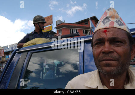 Katmandou, Népal, 10 septembre 2003 : un Népalais ressemble à la protestation que dans la rue principale de Katmandou comme police népalaise montent la garde sur un pick up avec un fusil sur la rue principale d'Kathymandu. La violence et la protestation ont grimpé au Népal après la lutte contre la guérilla maoïste pour abolir la monarchie. Flexibilite' Banque D'Images
