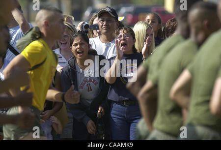 25 octobre 2003. Marine Corps Recruter Depot, San Diego, Californie, USA. Yoland Bitsui (centre gauche) et sa mère Ester Bitsui (centre droit) bravo pour les recruter, Nate Bitsui, comme il court par un quatre mile run avec son peloton. Le père de Nate, Francis Bitsui (centre) des enregistrements vidéo de l'événement. Banque D'Images