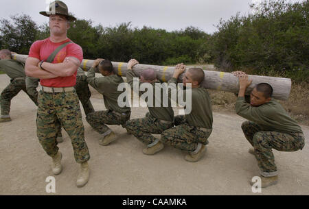 25 octobre 2003. Marine Corps Recruter Depot, San Diego, Californie, USA. Julio Nez, (à droite), s'efforce de tenir sa partie d'un journal que son instructeur de forage, le s.. Danny Tompkins, proclame son mécontentement quant à la performance du peloton au cours de leurs exercices de journal. Cre obligatoire Banque D'Images