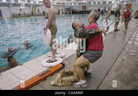 25 octobre 2003. Marine Corps Recruter Depot, San Diego, Californie, USA.. Julio Nez, après avoir été med hors de la piscine, est levé sur ses pieds par le capitaine D. J. Sanchez, le commandant de la série, après avoir échoué dans sa première tentative de qualification de natation. Crédit obligatoire : photo par Earnie Grafton/San Diego Banque D'Images