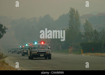 Oct 27, 2003 ; Los Angeles, CA, USA ; les policiers en patrouille comme l'approche des flammes d'un incendie de vigueur les résidents à évacuer leur maison dans une communauté fermée exclusive dans les collines au-dessus de la section Chatsworth de Los Angeles. Les incendies de Californie ont tué 16 personnes, détruit près de 2 000 home Banque D'Images