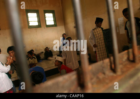 BANDUNG, Java ouest, INDONÉSIE - Le 14 décembre 2003, passant leurs jours ensemble les jeunes délinquants sont verrouillés pendant deux jours avant d'être admis à l'extérieur. Avec seulement deux petites fenêtres qui illuminent les jeunes délinquants la cellule est sombre, humide et souvent dangereuse pour les jeunes hommes dans l'étroit Banque D'Images