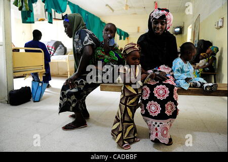 Le 5 août, 2010 - Kano, Kano, Nigéria - Mariam Abubakar est assis avec sa fille Zaniab, 3, après que l'enfant a reçu pour son traitement de la lumière de la polio. Mariam est séparée de Zaniab du père ; elle a refusé des vaccinations pour Zaniab et promet de faire de même pour son bébé, non identifié sur la droite. Femme et Banque D'Images