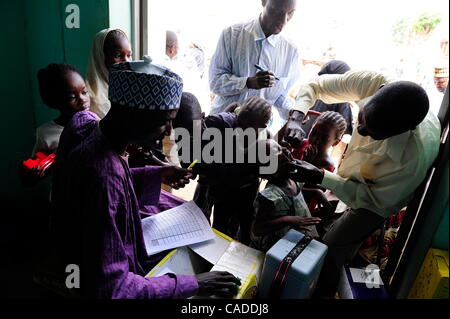 Le 5 août, 2010 - Kano, KANO, NIGERIA - un enfant de moins de cinq ans reçoit deux gouttes de vaccin contre la polio sur sa langue de vaccinatrice Sani Mohammed, un vaccin à l'arrêt du site. Vaccination dans la zone d'administration, en Fagge Kwciri Ward, à la recherche pour les enfants de moins de cinq ans sur Banque D'Images