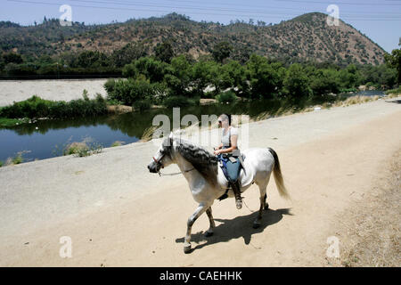 30 juillet 2010 - Los Angeles, Californie, USA - Marine Hoffman rides Contador le long d'un chemin sur le côté de la Los Angeles River près de la section Atwater de Los Angeles. Une récente décision de l'EPA que la dessiccation fréquemment, constamment en dérision Los Angeles River est ''navigables'' pourrait ouvrir la voie à une Banque D'Images