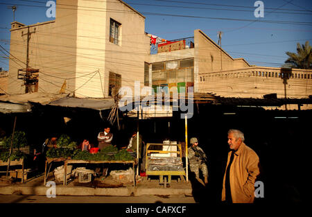 21 févr. 2008 - Bagdad, Irak - Shoppers de leurs affaires comme un 82nd Airborne Division parachutiste prendre un genou dans le marché au poisson de l'enclave sunnite d'Shabakar dans le quartier de Rabi de Bagdad. (Crédit Image : © Andrew Craft/ZUMA Press) Banque D'Images