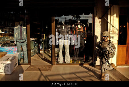 21 févr. 2008 - Bagdad, Irak - Shoppers de leurs affaires comme un 82nd Airborne Division parachutiste prendre un genou dans le marché au poisson de l'enclave sunnite d'Shabakar dans le quartier de Rabi de Bagdad. (Crédit Image : © Andrew Craft/ZUMA Press) Banque D'Images