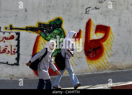 24 déc., 2007 - La ville de Gaza, bande de Gaza - une école palestinienne filles passe devant une lecture graffiti en arabe 'Hamas', le mouvement islamiste palestinien radical, dans le centre de la bande de Gaza du camp de réfugiés de Bureij. Deux membres du Hamas ont été tués et un troisième a été gravement blessé personne tôt ce matin Banque D'Images