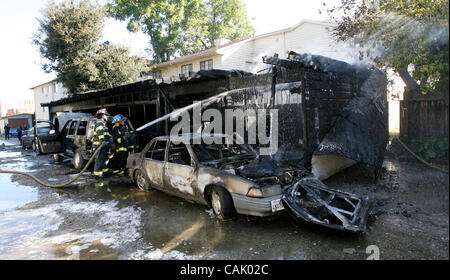 3 octobre 2007 - East Palo Alto, CA, USA - Menlo Park les pompiers éteindre les points chauds à un matin tôt East Palo Alto, Californie, le feu , le mercredi 3 octobre 2007. Le brasier était une alarme 2 et figure au garage et détruit certaines voitures en stationnement. (Crédit Image : © John Green/Pays de San Mateo Banque D'Images