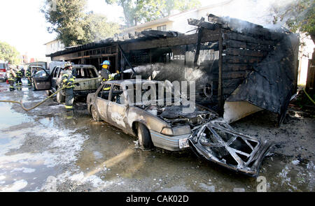 3 octobre 2007 - East Palo Alto, CA, USA - Menlo Park les pompiers éteindre les points chauds à un matin tôt East Palo Alto, Californie, le feu , le mercredi 3 octobre 2007. Le brasier était une alarme 2 et figure au garage et détruit certaines voitures en stationnement. (Crédit Image : © John Green/Pays de San Mateo Banque D'Images