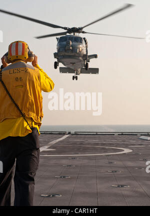 10 avril 2012 la Floride, Maître de Manœuvre 3e classe Robert signaux Chittenden et MH-60R Seahawk, affecté à la "Swamp Foxes" d'hélicoptères de l'Escadron 74 grève maritime, à terre sur le pont d'envol du navire de combat littoral Indépendance USS LCS (2). Banque D'Images