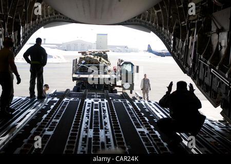 Un Alaska Air National Guard loadmaster guides une assurance de la palette sur un Air Force C-17 Globemaster III à Joint Base Elmendorf-Richardson, le 9 avril, avant de se rendre à Nome en soutien de l'opération de l'Arctique. Banque D'Images