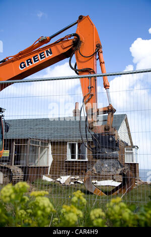 Norfolk, Royaume-Uni. Mercredi 11 avril 2012. Les Bulldozers se préparer pour cette après-midi la démolition de 9 propriétés à Beach Road, Happisburgh à Norfolk à mesure qu'ils sont dangereusement près de tomber dans la mer en raison de l'érosion côtière. Accepté l'indemnisation par les résidents de North Norfolk District Council à déplacer. Banque D'Images