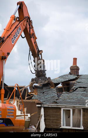 Norfolk, Royaume-Uni. Mercredi 11 avril 2012. Commencer la démolition de creuseurs 9 propriétés à Beach Road, Happisburgh à Norfolk à mesure qu'ils sont dangereusement près de tomber dans la mer en raison de l'érosion côtière. Ligne de crédit : Crédit : Paul Lilley/Digitalshot.co.uk / Alamy Live News Banque D'Images