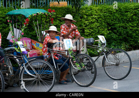 Les pilotes de pousse-pousse à vélo ou à vélo freinent lors de la célébration du nouvel an thaïlandais sur la route de Sukhumvit, Bangkok, Thaïlande, le vendredi 13 avril 2012. Bangkok célèbre le nouvel an thaïlandais avec le festival traditionnel de l'eau Songkran. Les cyclos sont respectueux de l'environnement. Crédit : Kraig Lieb Banque D'Images