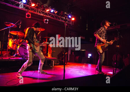 Le guitariste Ryan Jarman (centre) à la guitare avec d'autres bandmember, frère jumeau, et le bassiste Gary Jarman (à droite) et le batteur/jeune frère Ross Jarman (à gauche) à Brighton Music Hall à Allston, Massachusetts le 14 avril 2012. Banque D'Images