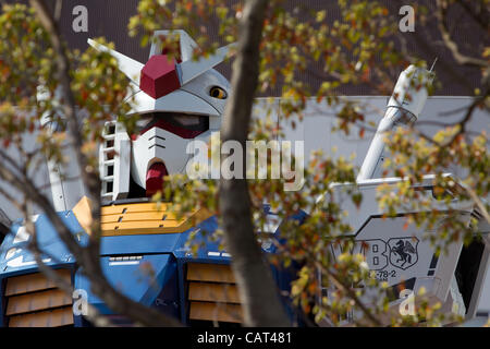 18 avril 2012, Tokyo, Japon - un 18-mètres de haut maquette à l'échelle de la populaire Gundam robot de la série anime japonais créé par Sunrise studios, est à l'affiche en face de Diver City Tokyo Plaza, un nouveau centre commercial à l'ouverture d'Odaiba le 19 avril. Banque D'Images