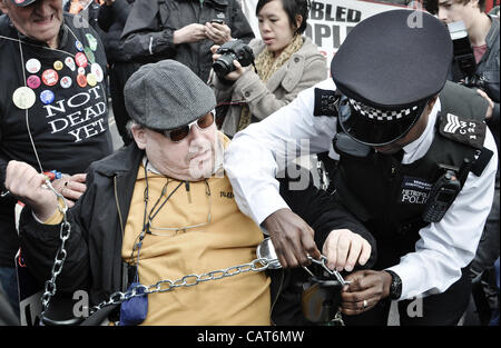 18/04/12, London, UK : sergent de police supprime les chaînes à partir d'un fauteuil roulant, comme handicapées manifestants bloquer les routes à Trafalgar Square. L'action a été pour protester contre les modifications apportées à des prestations d'invalidité, entre autres questions. Banque D'Images