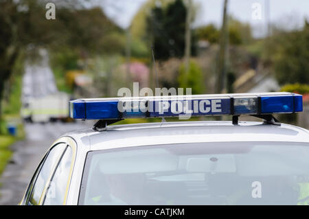 Voiture de police PSNI sur la scène d'un bombscare comme un dispositif suspect est trouvé sur une route rurale, avec ATO de l'armée dans l'arrière-plan Banque D'Images