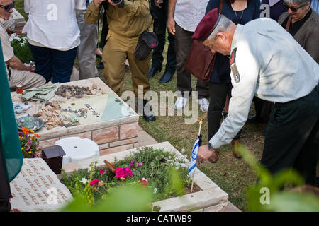 Chef d'état-major des FDI, Lieutenant-général, Benny Gantz, endroits petits drapeaux en berne avec rubans noirs symbolisant le deuil sur les tombes de soldats morts au cimetière militaire du Mont Herztel avant Memorial Day. Jérusalem, Israël. 22-Apr-2012. Banque D'Images