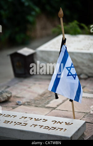 Chef d'état-major des FDI, Lieutenant-général, Benny Gantz, endroits petits drapeaux en berne avec rubans noirs symbolisant le deuil sur les tombes de soldats morts au cimetière militaire du Mont Herztel avant Memorial Day. Jérusalem, Israël. 22-Apr-2012. Banque D'Images