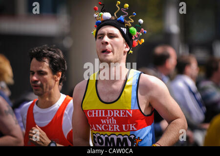 Londres, Canary Wharf, près de mille 18, 22 avril 2012, les concurrents dans le Marathon de Londres 2012 ont presque 10 miles plus d'aller. Un homme porte un chapeau à pipecleaners colorés de se faire remarquer. Banque D'Images