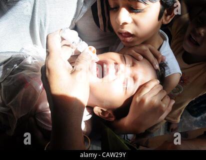 Un travailleur de la santé administre le vaccin contre la poliomyélite chute à un enfant pendant trois jours de la campagne d'éradication de la poliomyélite dans la région de Karachi le Lundi, Avril 23, 2012. Banque D'Images