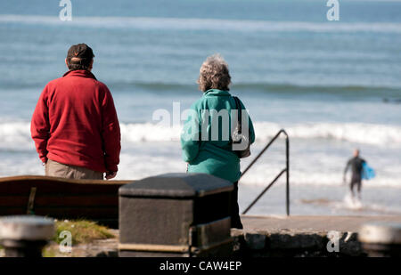 Swansea - UK - 24 avril 2012 - Un couple de regarder les surfeurs profiter du soleil et surf à Caswell Bay sur la péninsule de Gower, près de Swansea ce matin. Banque D'Images