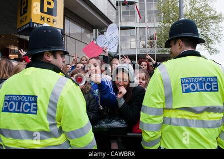 Londres, Royaume-Uni. 25/04/12. Justin Beiber fans être contenue par la Police métropolitaine à l'extérieur de l'hôtel Royal Garden à Kensington. Banque D'Images