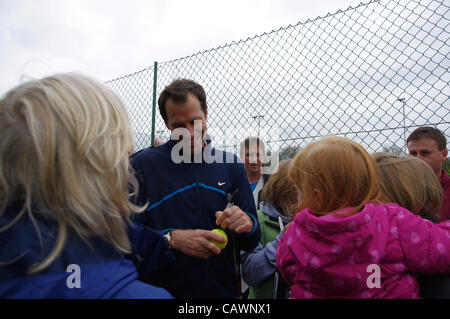 Greg Rusedski Tennis star signe une balle de tennis pour un jeune fan de tennis à l'ouverture de Barnt Green Sports Club de neuf en terre battue et projecteurs. Les améliorations permettront de continuer à jouer par tous les temps. Date 28 avril 2012. Banque D'Images