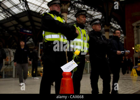 Londres, Royaume-Uni. 1/4/12. Les agents de police se sont réunis à la gare de Liverpool comme Occupy protestataire a donné des fleurs pour les navetteurs pour marquer la Journée internationale du travail. La journée internationale du travail (également connu sous le nom de May Day) rassemble des syndicalistes, les travailleurs des nombreuses communautés internationales à Londres Banque D'Images