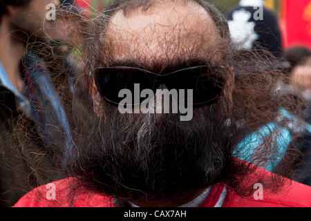 Londres, Royaume-Uni. 1 mai, 2012. L'homme couvre son visage avec sa barbe pour protester contre un manifestant dé-masqué par la police lors d'une manifestation organisée par les syndicats et autres organisations de travailleurs pour marquer le Jour annuel du mois de mai ou la Fête du travail dans le centre de Londres, au Royaume-Uni. Banque D'Images