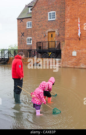 Deux petites filles profitant de l'occasion d'aller pêcher dans la chaussée à côté de l'abbaye de Tewkesbury, après la rivière Avon éclater ses banques le 01 mai 2012 Banque D'Images