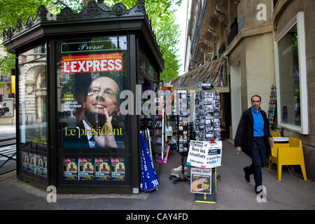 Boulevard Saint-Germain, Paris, French Elections.07.05.2012 l'image montre un homme qui passe devant un kiosque parisien vendant le magazine l'Express avec le président nouvellement élu François Hollande après les résultats des élections de nuits précédentes. Banque D'Images