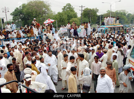 Les producteurs de lait se rassemblent à court road comme ils protestent pour augmenter le prix du lait dans la région de Lahore, le jeudi 10 mai 2012. Banque D'Images