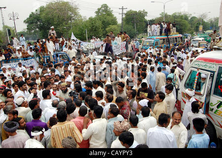 Les producteurs de lait se rassemblent à court road comme ils protestent pour augmenter le prix du lait dans la région de Lahore, le jeudi 10 mai 2012. Banque D'Images