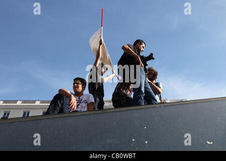 Madrid, Espagne. Les gens s'asseoir dessus de la route à l'entrée de la station de métro Sol à Puerta del Sol au cours de l'année anniversaire de la Indignado circulation le 15 mai 2012. Ce mouvement a suscité des protestations similaires occupent dans le monde. Banque D'Images