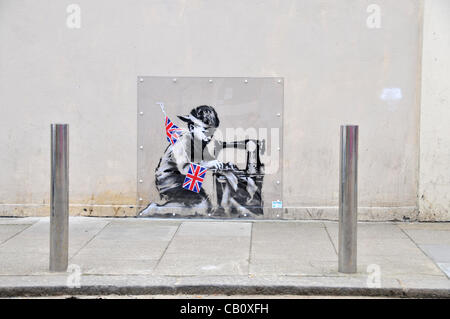 La nouvelle oeuvre de graffiti Banksy '' montrant un garçon avec une machine à faire de l'ensemencement Union Jack noir sur le mur de l'Poundland store à Wood Green, Londres. Jeudi 17 Mai 2012 Banque D'Images