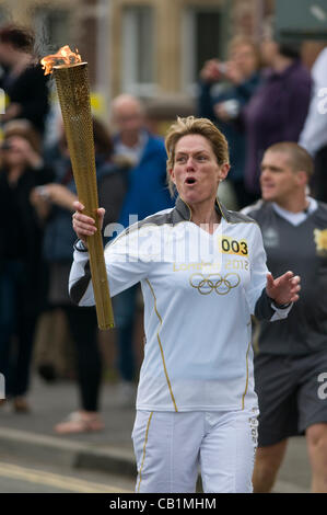 Le troisième jour du relais de la flamme olympique de Londres 2012 commence à Exeter. Tracy Markell, 44 ans, de Sidmouth, porte la flamme. Banque D'Images