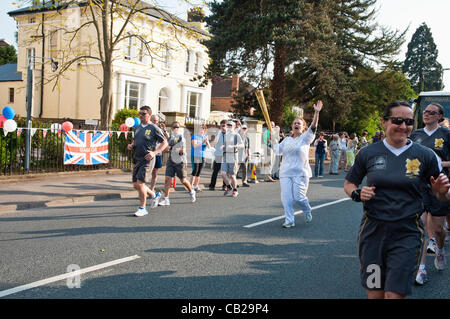 Avec excitation courir avec la flamme olympique, accompagné d'un garde de la Police métropolitaine. ( 4 de 4 ) Banque D'Images