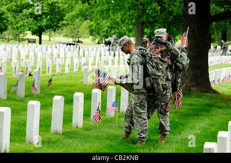 Les membres de l'US 3rd Infantry connu comme la vieille garde place des drapeaux américains sur pierres tombales au cimetière national d'Arlington en l'honneur de Memorial Day 24 mai 2012 à Arlington, VA. Cette tradition, connu sous le nom de drapeaux en, a été menée chaque année depuis la vieille garde a été désigné comme l'armée officielle du c Banque D'Images