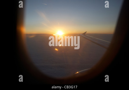 Lever du soleil à travers la fenêtre de l'avion de passagers durant le vol le vol de l'effet yeux rouges la traversée de l'Atlantique Banque D'Images