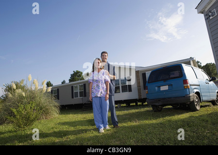 Portrait d'un couple de col bleu à côté du vieux van à l'extérieur de maison mobile Banque D'Images