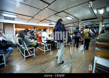 Les passagers à bord du Star ferry de nuit l'île de hong kong, Hong Kong, Chine action motion blur Banque D'Images