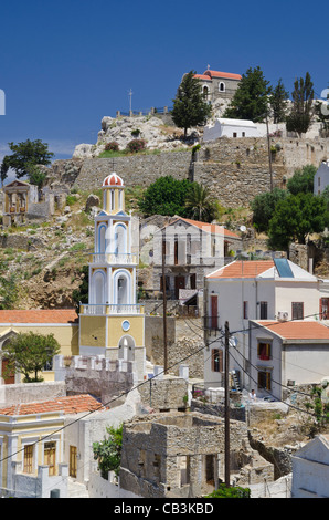 En tête de l'église vieux Kastro murs au-dessus des maisons néoclassiques de l'Horio, Symi, Grèce Banque D'Images