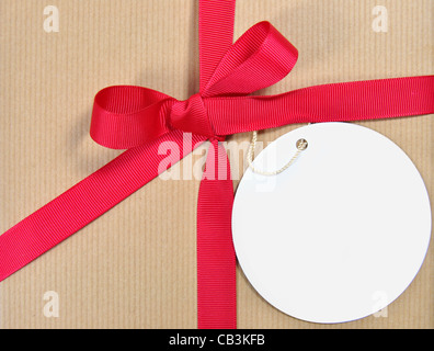 Présent attaché avec un ruban arc avec une étiquette cadeau vierge Banque D'Images