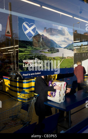 L'intérieur de la direction de Shoppers Glasgow supermarché Lidl avec les couleurs et caisse & Bienvenue à l'Écosse de l'affiche. Banque D'Images