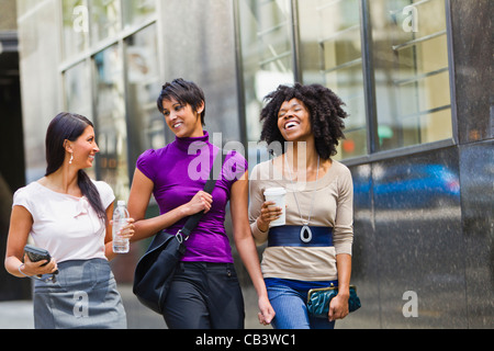 Trois businesswomen walking outside office Banque D'Images