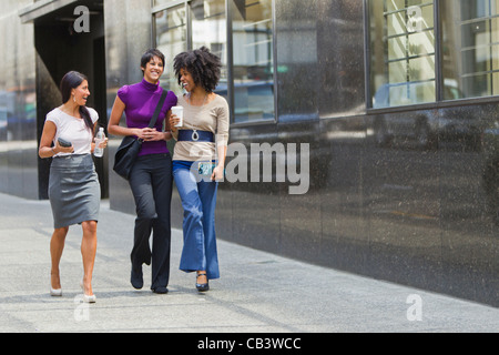 Trois businesswomen walking outside office Banque D'Images